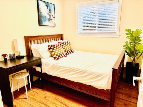 a bedroom with a bed and a desk and a table and a plant at Cozy 2 beds Spacious rooms,Close to transit in Vancouver