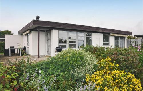 a white house with a garden in front of it at Three-Bedroom Holiday Home In Nyborg in Nyborg