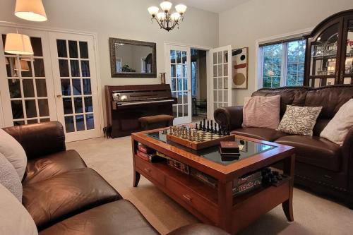 a living room with a coffee table and a piano at Summer Getaway with Pool and Nearby Attractions in Cobourg