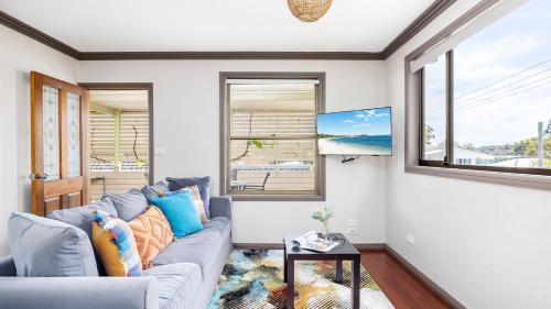 a living room with a blue couch and a window at Lionel Gem in Shoal Bay