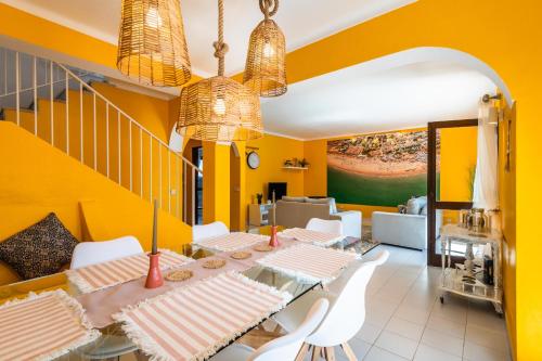 a dining room with yellow walls and a table and chairs at Villa Canto II - 500m from the Beach - Private Swimming Pool - Wi Fi in Guia