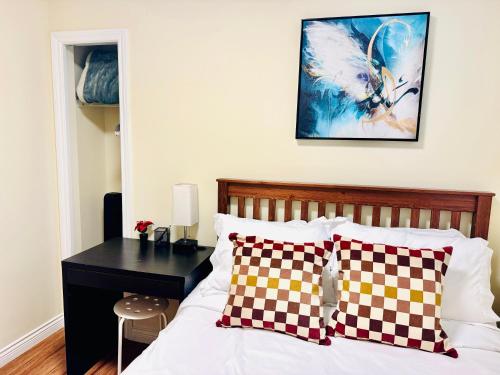 a bedroom with a bed with a desk and a picture on the wall at Cozy 2 beds Spacious rooms,Close to transit in Vancouver