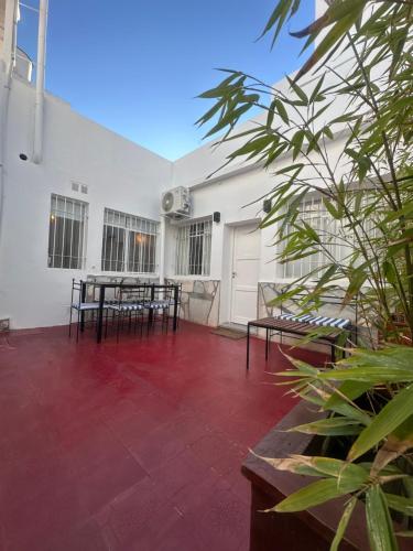 un patio con mesas y bancos en un edificio blanco en URBAN 483, en La Falda