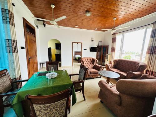 a living room with a table and chairs at Green Tree Apartments in Dehiwala