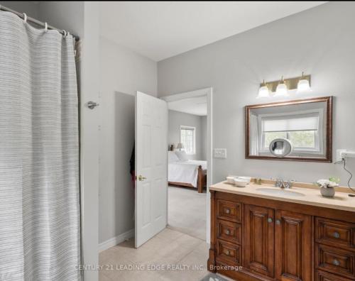 a bathroom with a sink and a mirror at Summer Getaway with Pool and Nearby Attractions in Cobourg