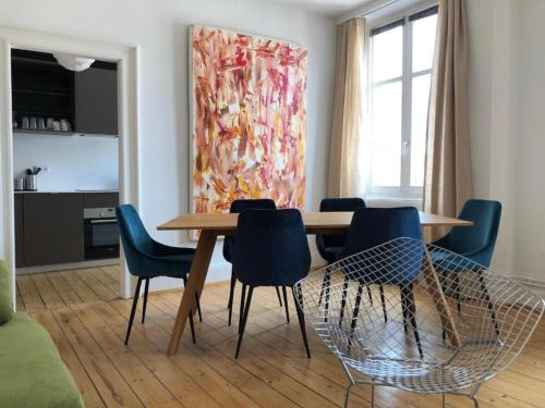 a dining room with a wooden table and blue chairs at PRALINE in Colmar