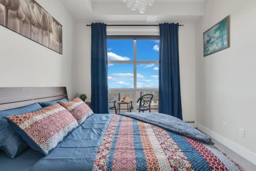 a bedroom with a bed and a window with a view at Elegant Downtown Condo with Balcony & Parking in Calgary