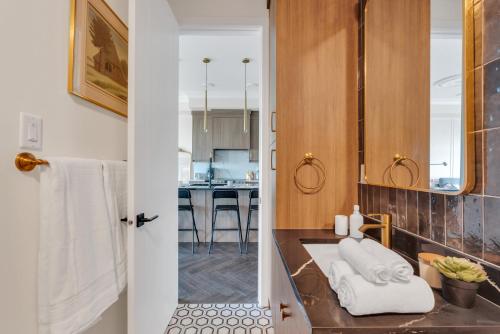 a bathroom with a sink with towels on a counter at Elegant Downtown Condo with Balcony & Parking in Calgary