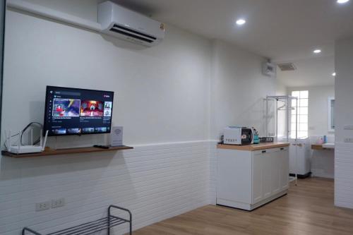 a room with a tv on the wall in a clinic at Oskar's House in Bangkok