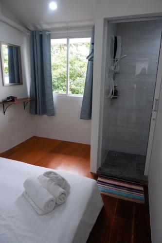 a bedroom with a bed with a glass shower at Oskar's House in Bangkok