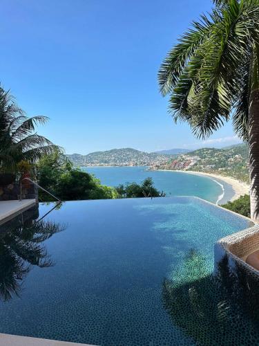 a large swimming pool with a view of a beach at Luxury Residence at Vista Bay 103 in Zihuatanejo