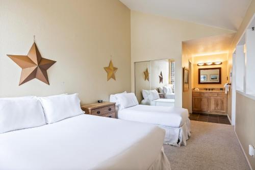 two beds in a hotel room with white sheets at Walk to Lift, Sleeps 6, Shared Hot Tub, Cozy Interiors, Gourmet Dining, Fireplace and Patio in Park City