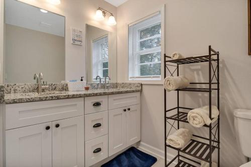 a white bathroom with a sink and a mirror at Charming 3-bedroom Home -Quiet East Atlanta Neighborhood in Atlanta
