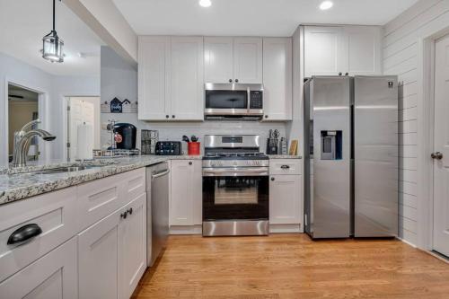 a kitchen with white cabinets and a stainless steel refrigerator at Charming 3-bedroom Home -Quiet East Atlanta Neighborhood in Atlanta
