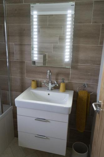 a bathroom with a sink and a mirror at Hollicarrs - The Rushes in Riccall
