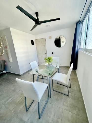 a dining room with a glass table and white chairs at Great condo in the best location in Puerto Vallarta