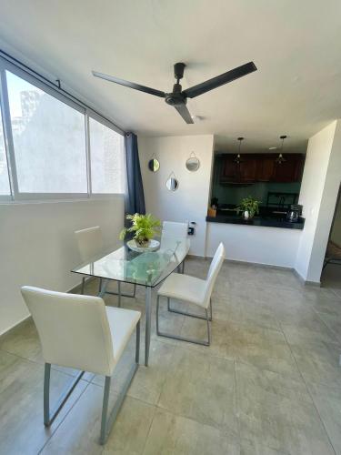 a dining room with a glass table and white chairs at Great condo in the best location in Puerto Vallarta