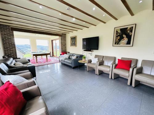 a living room with couches and a flat screen tv at Les Charmes in Chevron