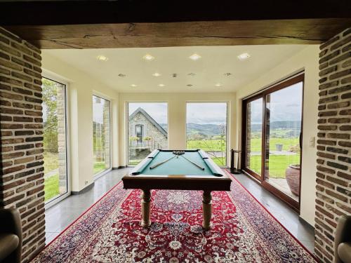 a pool table in a room with large windows at Les Charmes in Chevron