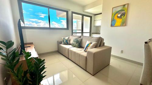 a living room with a couch and some windows at Apt Araras - Próximo ao Shopping in Palmas