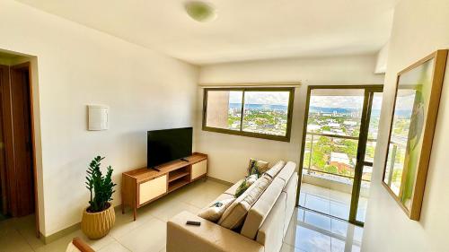 a living room with a couch and a flat screen tv at Apt Araras - Próximo ao Shopping in Palmas