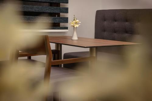 a table and a chair with a vase with a flower at Gkeea Boutique Hotel in Ierissos