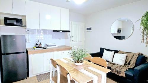 a kitchen and a living room with a table at Marina Oasis Two Bed Room Condo Unit in Dumaguete
