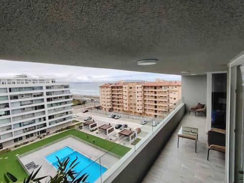 a balcony with a swimming pool and some buildings at Exclusivo Departamento con Vista Panorámica al Mar a Solo 50 Metros de la Playa in La Serena