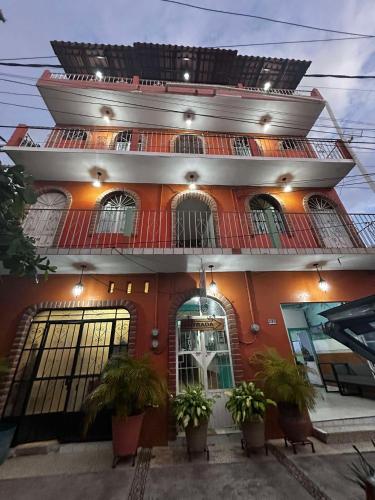 a red building with plants in front of it at Hotel Libramiento Puerto Vallarta in Puerto Vallarta