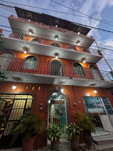 a red building with plants in front of it at Hotel Libramiento Puerto Vallarta in Puerto Vallarta