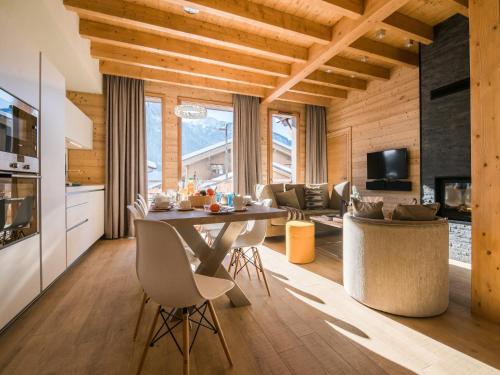une cuisine et un salon avec une table et des chaises dans l'établissement Chalet in Megève with Mont-Blanc Views, à Praz-sur-Arly