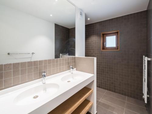 une salle de bain avec deux lavabos et un miroir dans l'établissement Chalet in Auris-en-Oisans with Balcony Views, à L'Alpe-d'Huez