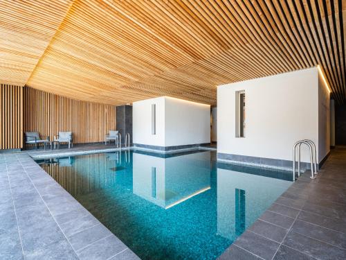 une grande piscine avec un plafond en bois dans l'établissement Chalet in Auris-en-Oisans with Balcony Views, à L'Alpe-d'Huez