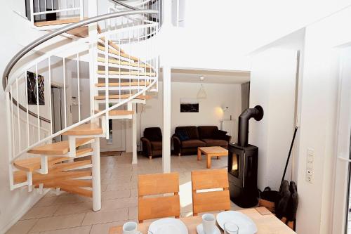 a living room with a spiral staircase and a living room at Sechendorf-Ferienhaus-Solhem-Sechendorf in Blekendorf