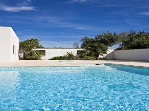 une piscine avec de l'eau bleue devant une maison dans l'établissement Charming Apt in Mandelieu, à Mandelieu-la-Napoule