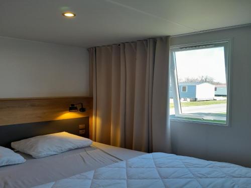 a bedroom with a bed and a window at Charming Breebos Getaway in Rijkevorsel