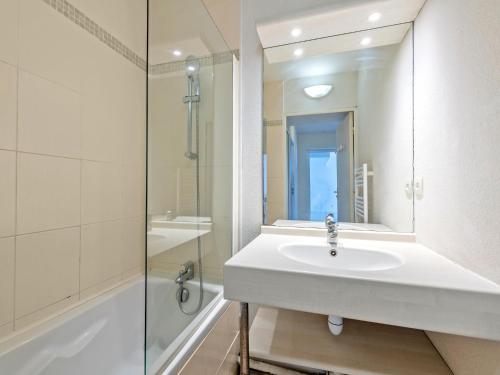 a white bathroom with a sink and a shower at Flat by Pointe St-Mathieu in Plougonvelin