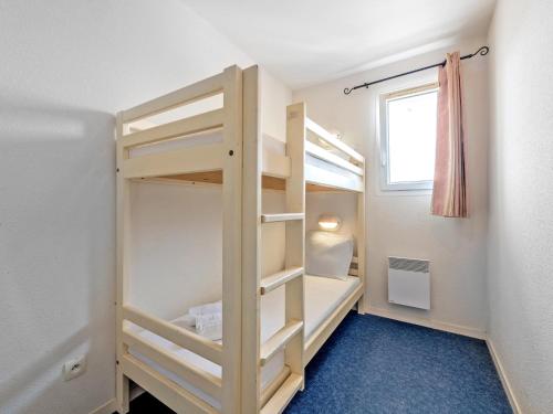 a bunk bed in a room with a window at Flat by Pointe St-Mathieu in Plougonvelin