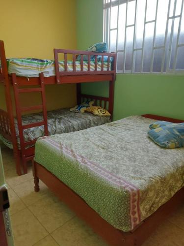 a bedroom with two bunk beds and a window at Puerto Pizarro INN in Puerto Pizarro