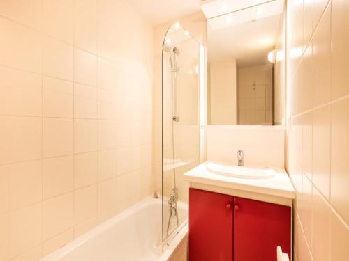 La salle de bains est pourvue d'une armoire rouge et d'un lavabo. dans l'établissement Apartment in France with Ski Views, à Valloire