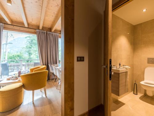 La salle de bains est pourvue de toilettes, d'une table et de chaises. dans l'établissement Chalet in Megève with Mont-Blanc Views, à Praz-sur-Arly