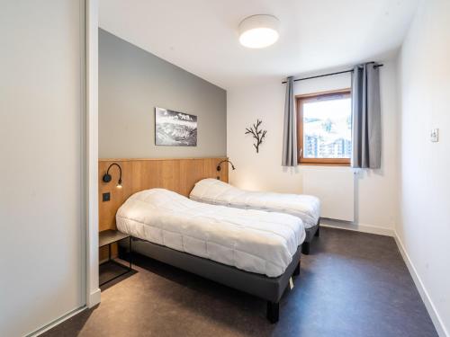 deux lits dans une petite pièce avec une fenêtre dans l'établissement Chalet Apartment in Auris-en-Oisans Alps, à L'Alpe-d'Huez