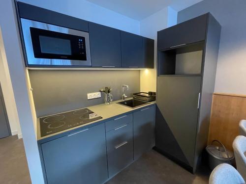 une petite cuisine avec une cuisinière et un micro-ondes dans l'établissement Chalet Apartment in Auris-en-Oisans Alps, à L'Alpe-d'Huez