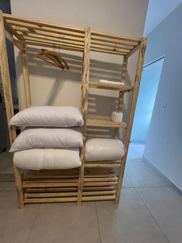 a stack of pillows on a shelf in a room at Flat por do Sol in Tiradentes