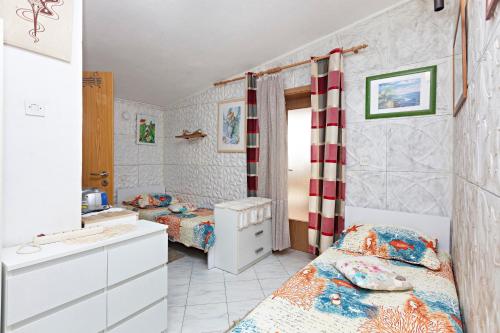 1 Schlafzimmer mit 2 Betten, einem Waschbecken und einem Spiegel in der Unterkunft Apartments by the sea Grebastica, Sibenik - 461 in Grebaštica