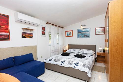 ein Schlafzimmer mit einem Bett und einer blauen Couch in der Unterkunft Apartments by the sea Grebastica, Sibenik - 461 in Grebaštica
