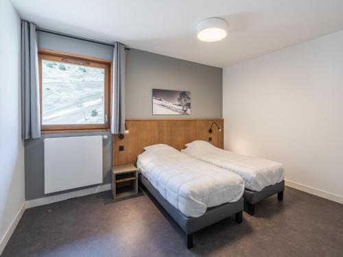 une chambre avec deux lits et une fenêtre dans l'établissement New apartments by the slopes in L'Alpe d'Huez, à L'Alpe-d'Huez