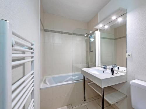 une salle de bain avec un lavabo et une baignoire dans l'établissement Vacation apartment in southern Brittany, à Plougonvelin