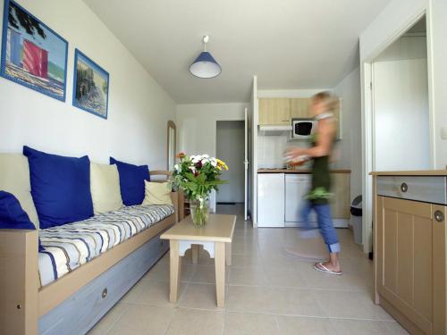 une femme dans un salon avec un canapé et des fleurs dans l'établissement Nice Holiday home with bath, à Ondres