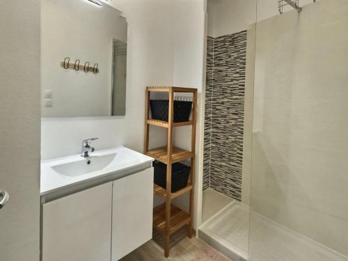 une salle de bain blanche avec un lavabo et une douche dans l'établissement Apartment in Valras-Plage near Sandy Beach, à Sérignan